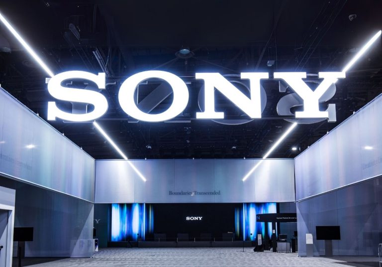 Um grande letreiro iluminado com a palavra "SONY" em um ambiente moderno e amplo. Curso: Aprenda com o Fundador da Sony.