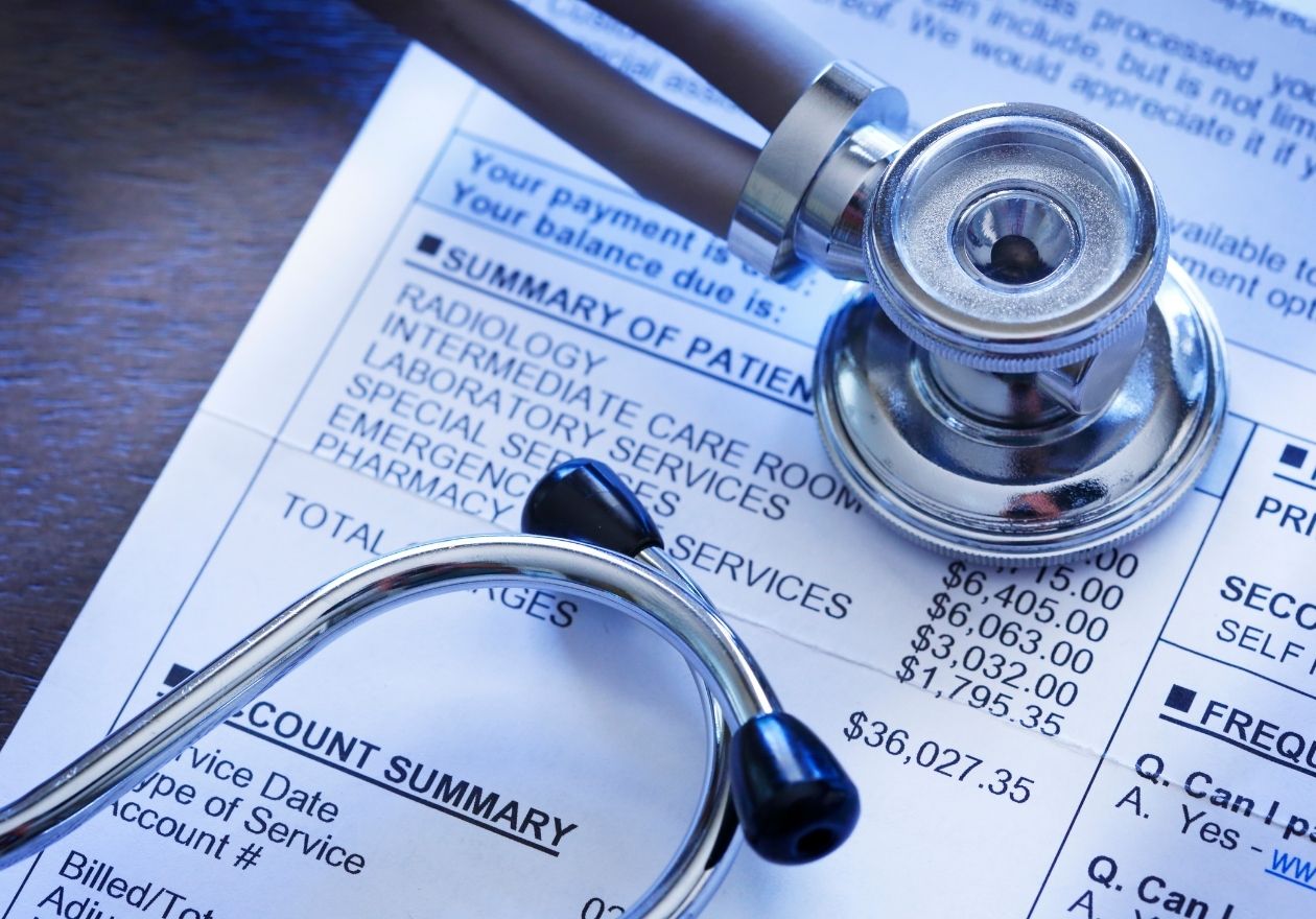 Um estetoscópio sobre um documento médico, com informações de saúde. Curso: Introdução à Gestão da Qualidade e Segurança em Saúde.