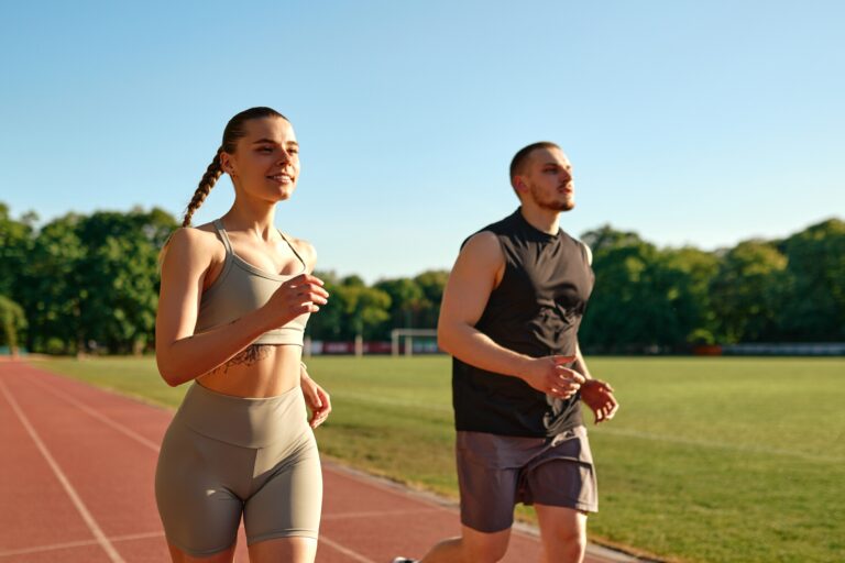 Fit,Young,Couple,Jogging,Together,On,Stadium,Track,In,The