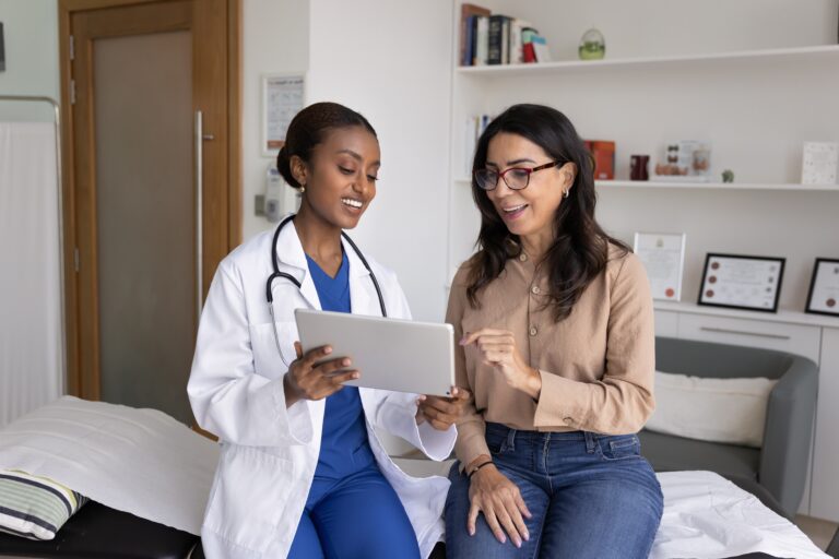 Positive,Mature,Patient,And,Young,Black,Doctor,Women,Using,Digital