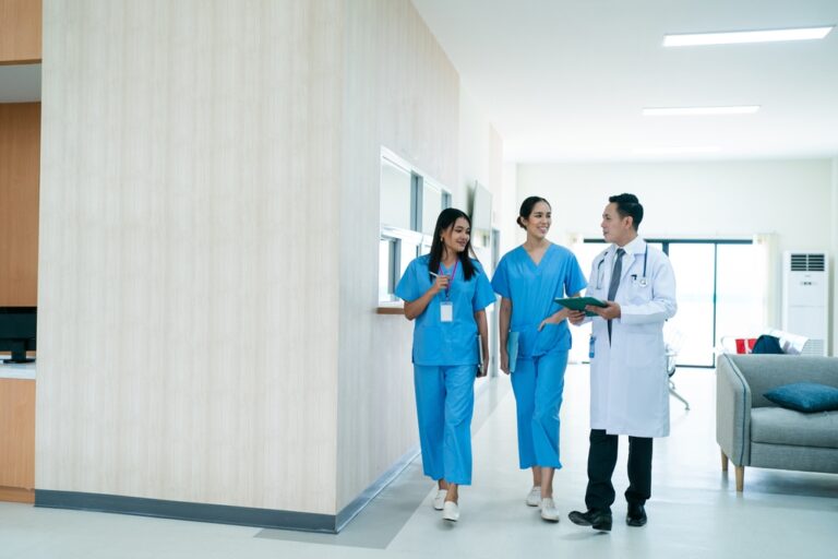 Mature,Female,Doctor,Discussing,Medical,Report,With,Nurses,In,Hospital