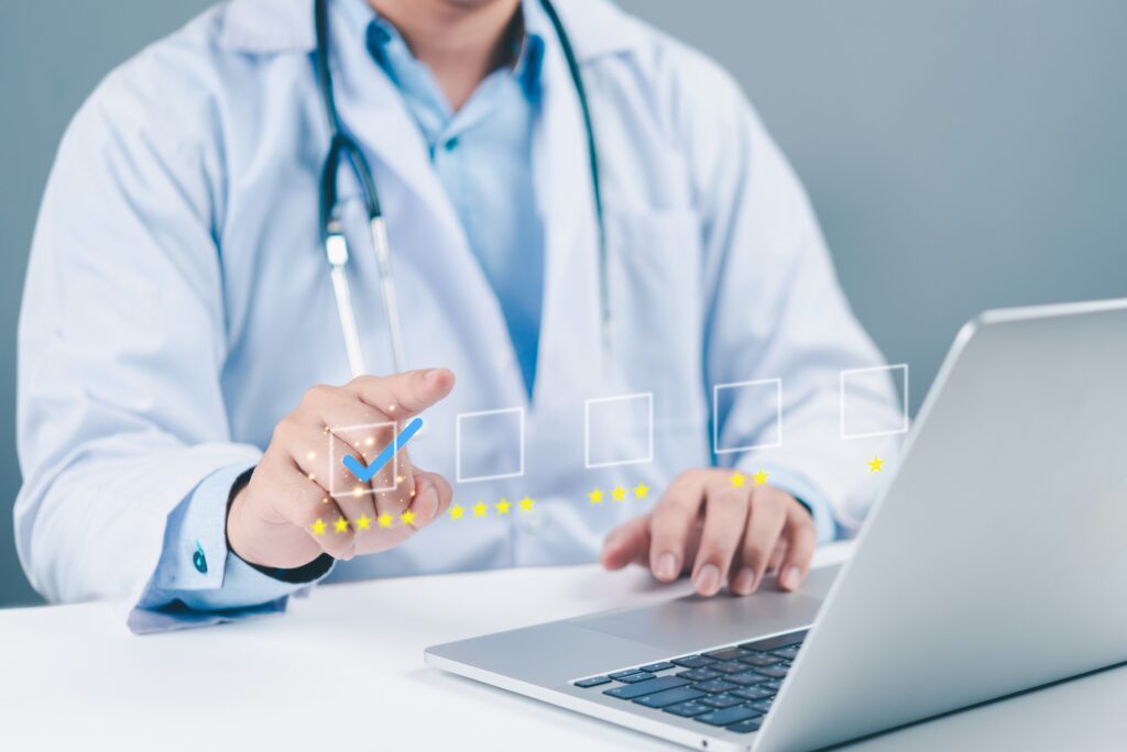 Médico em frente ao notebook marca a avaliação de cinco estrelas, representando a nota de qualidade e os bônus do IDSS.